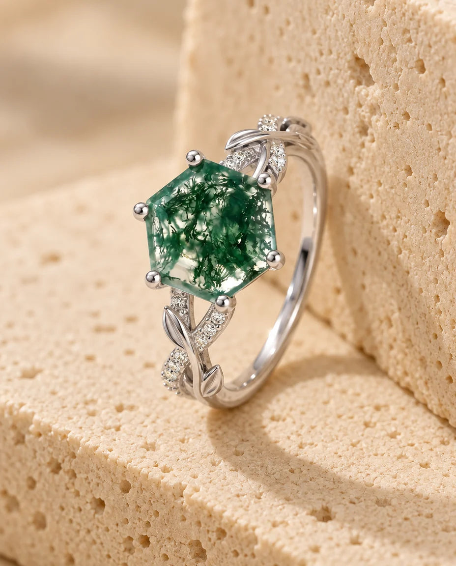Anillo de ágata musgosa hexagonal de 8 mm - expuesto sobre un bloque de travertino