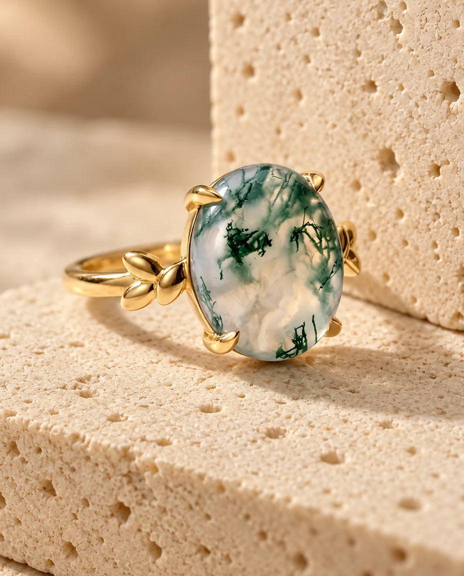 Anillo de ágata musgosa ovalada 10x12 mm - expuesto sobre un bloque de travertino