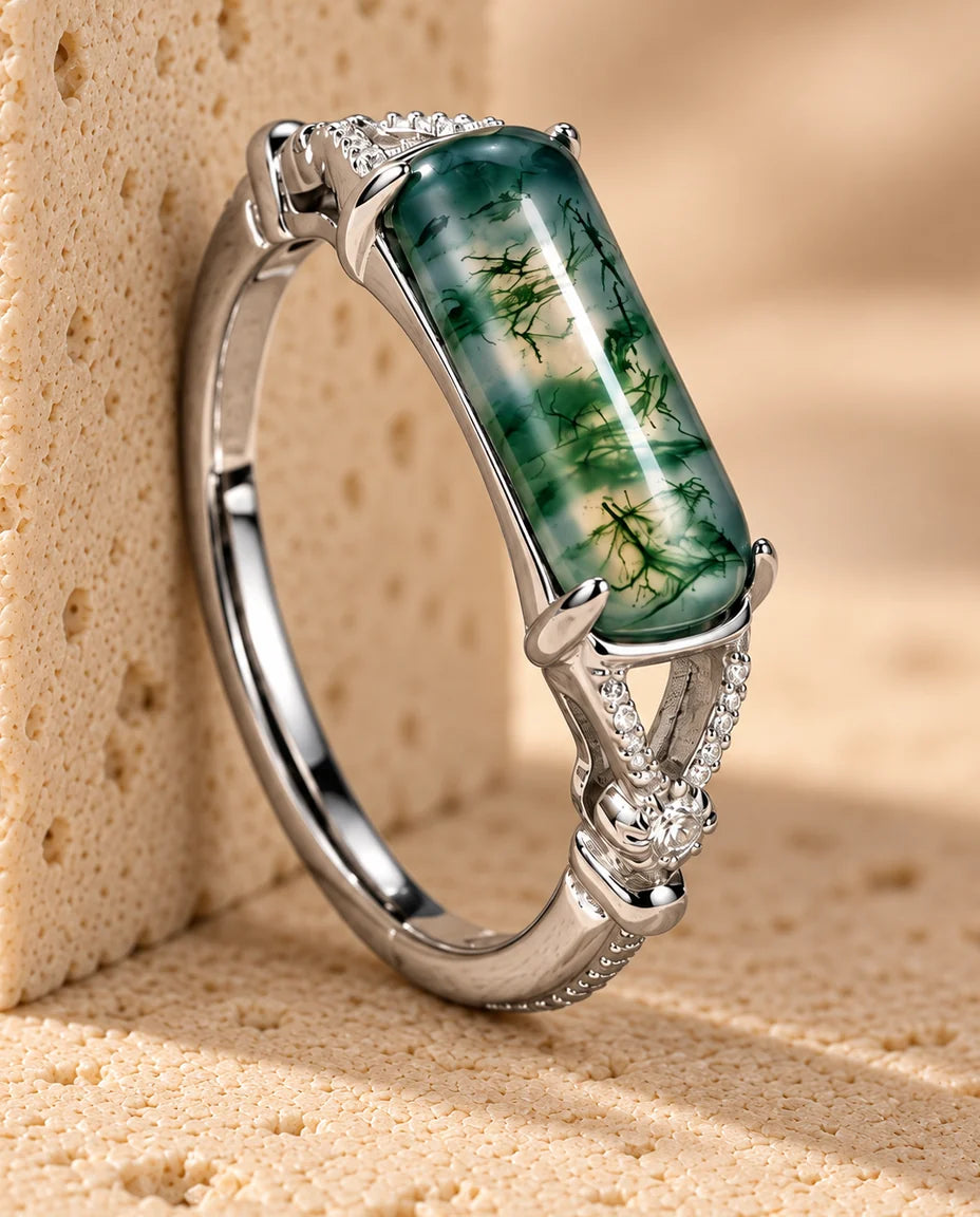 Anillo de ágata musgosa rectangular engastada en horizontal - expuesto sobre un bloque de travertino