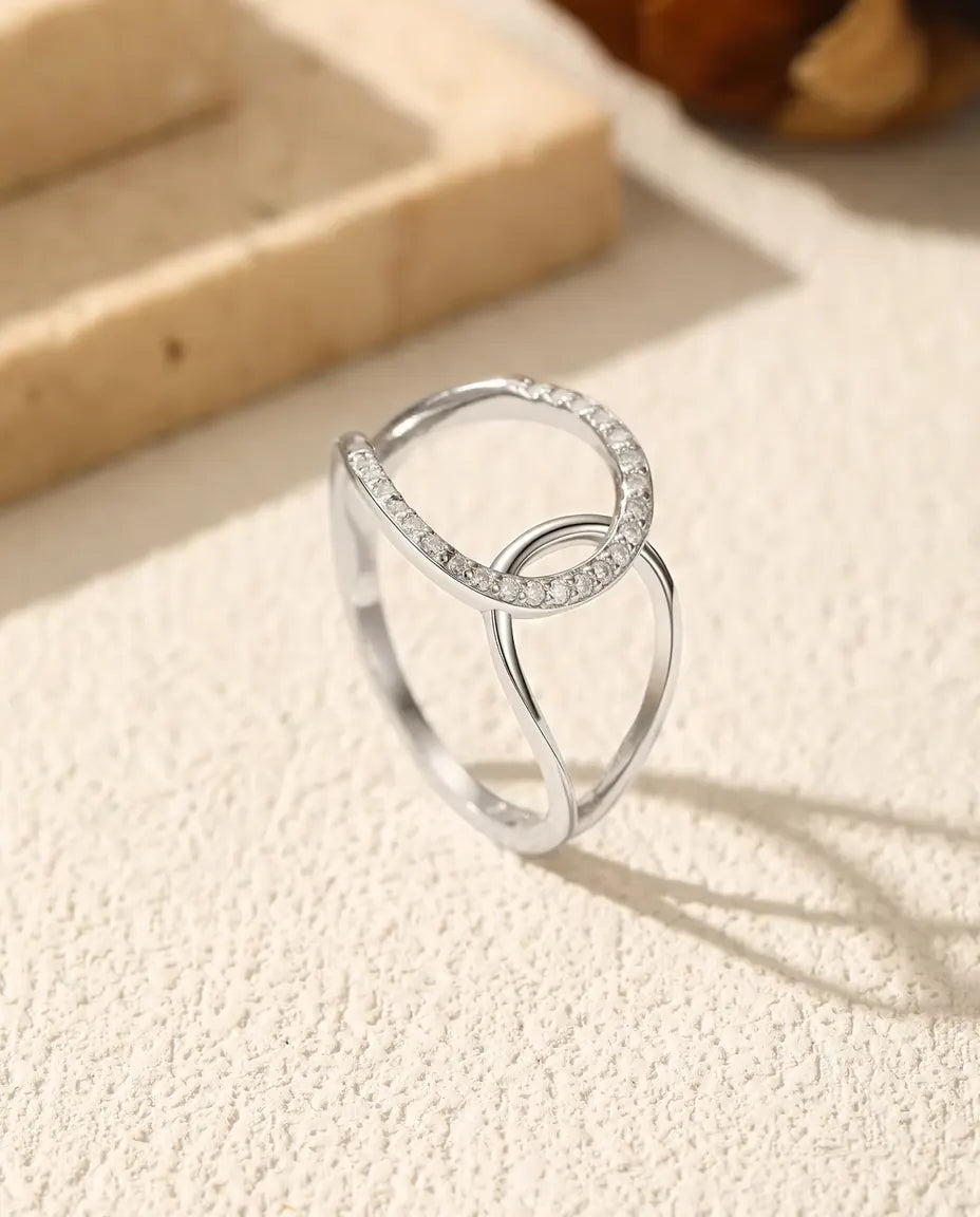 Anillo de Círculos Entrelazados en Plata 925 - de pie sobre una superficie clara con textura