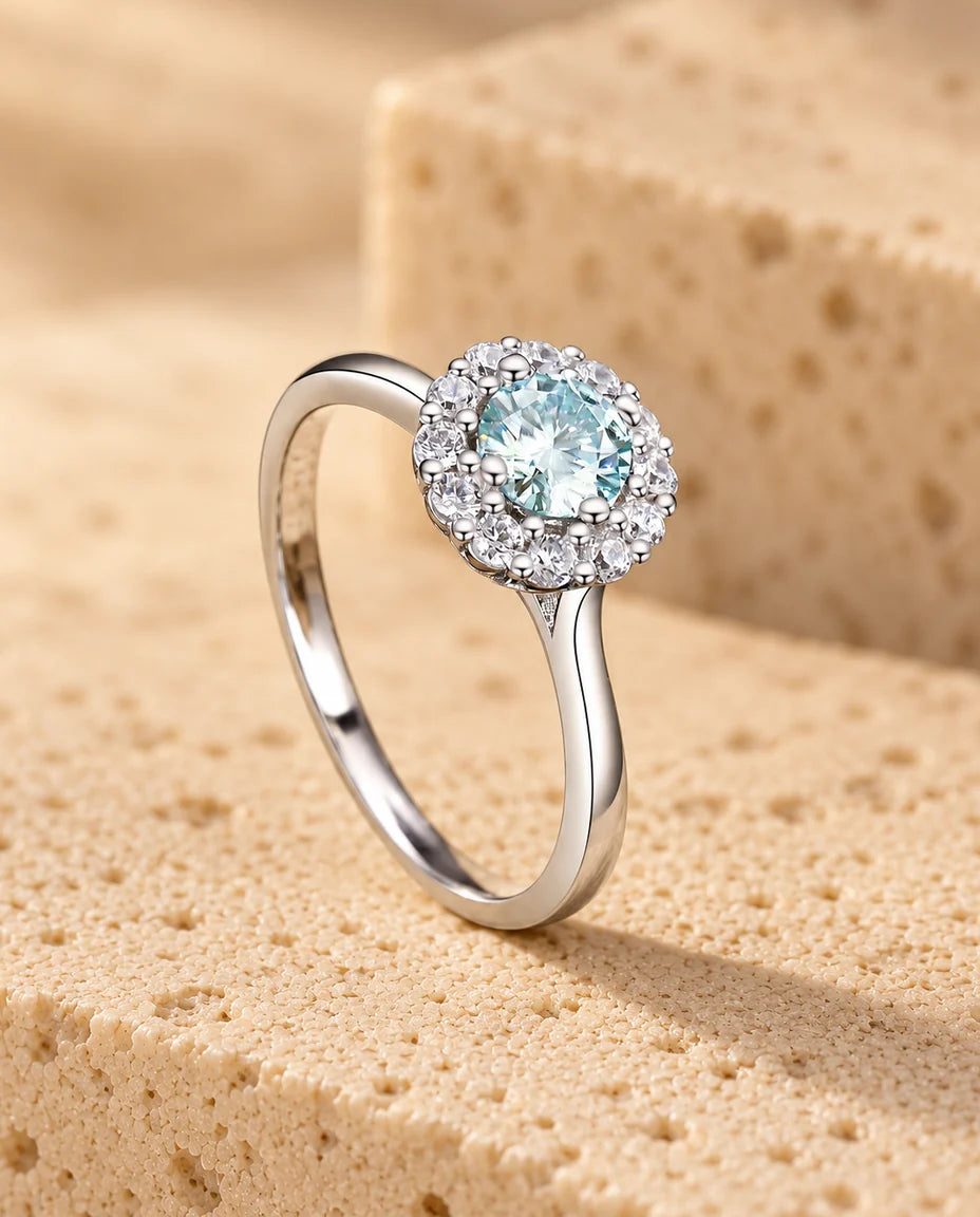 Anillo de moissanita con halo verde azulado 0 - expuesto sobre un bloque de travertino