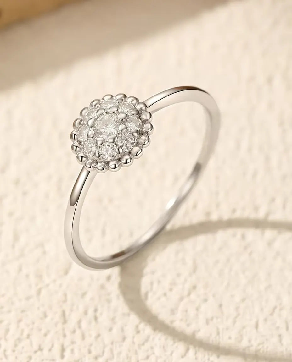 Anillo Moissanita Roseta - piedra central de 0,06 ct y ocho piedras en una orla perlada de 8 mm en plata 925, tallas 5 a 9