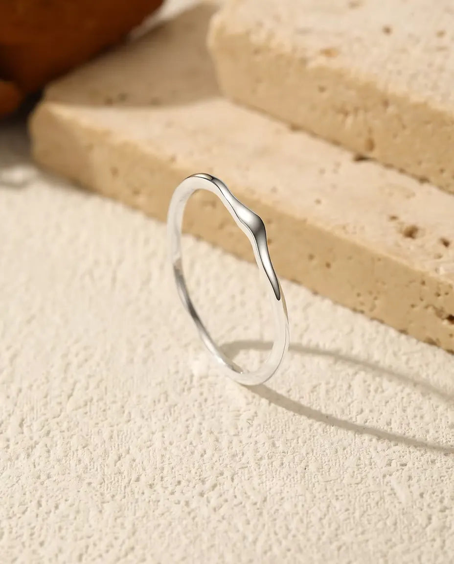 Anillo Ondulado Apilable en Plata 925 - de pie sobre una superficie clara con textura