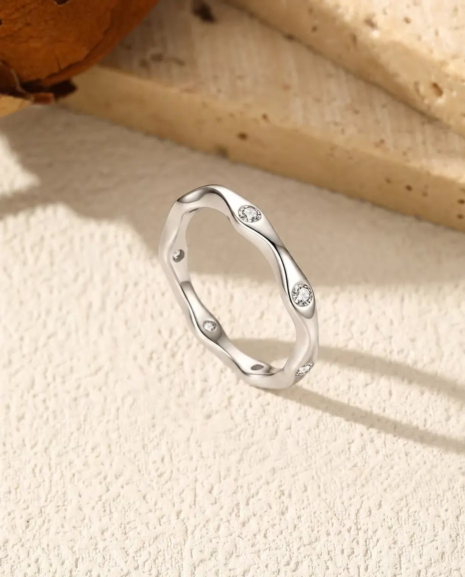 Anillo Ondulado de Moissanita en Plata 925 - de pie sobre una superficie clara con textura