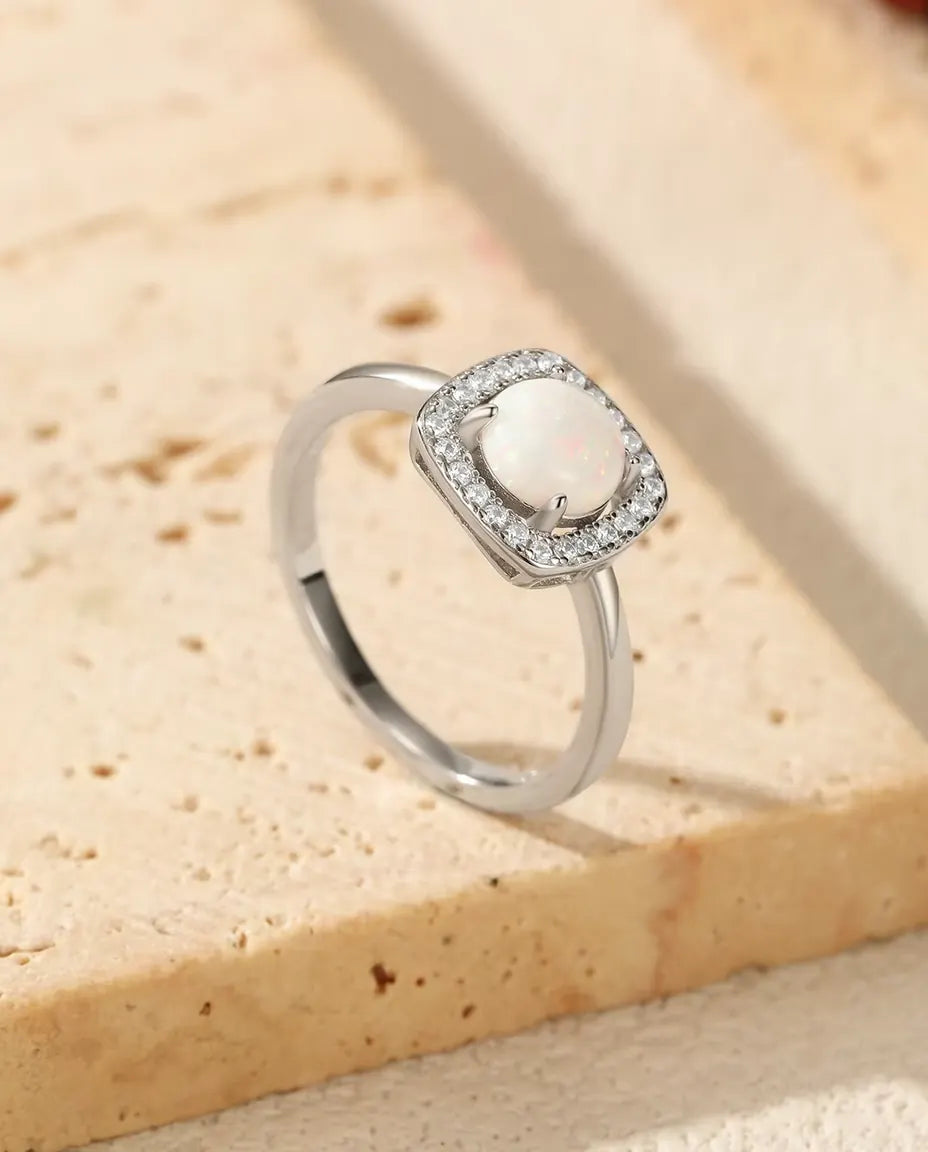 Anillo de Ópalo con Halo en Plata 925 - apoyado en el borde de una losa de travertino