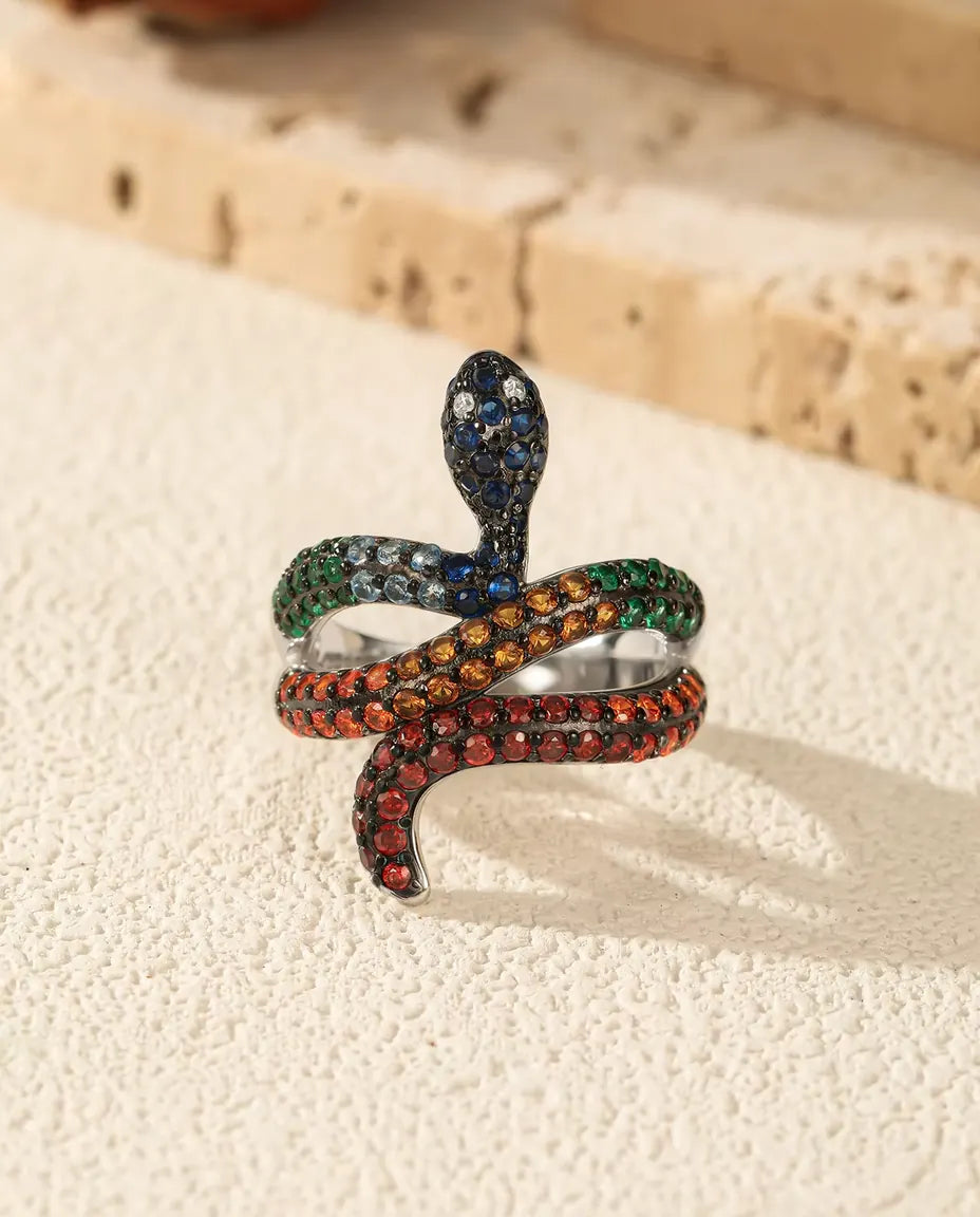 Anillo Serpiente en Plata 925 con Piedras Arcoíris - de pie sobre una superficie clara con textura