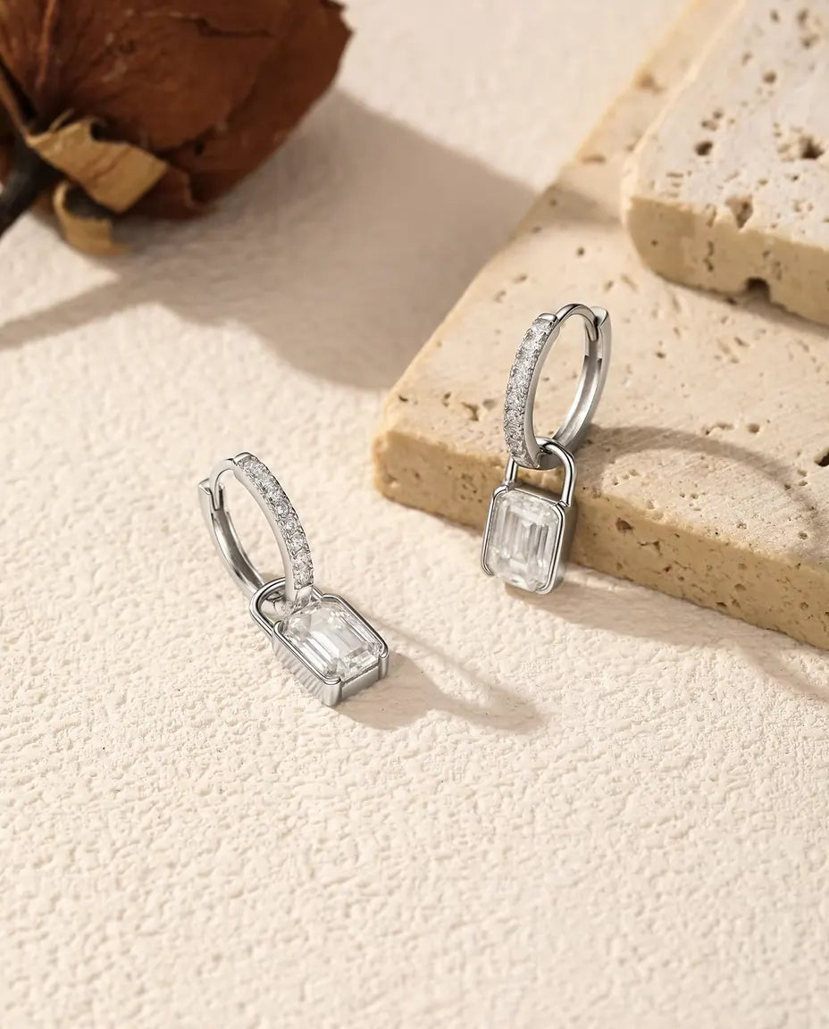 Pendientes de Aro con Candado de Moissanita en Plata 925 - colocados junto a una losa de travertino