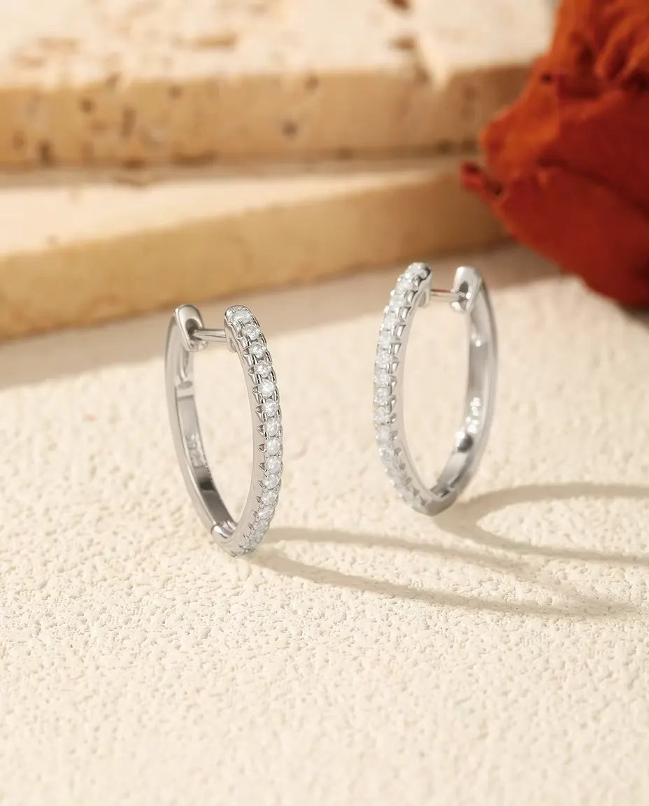 Pendientes de Aro de Moissanita en U en Plata 925 - el par uno junto al otro sobre una superficie clara con textura