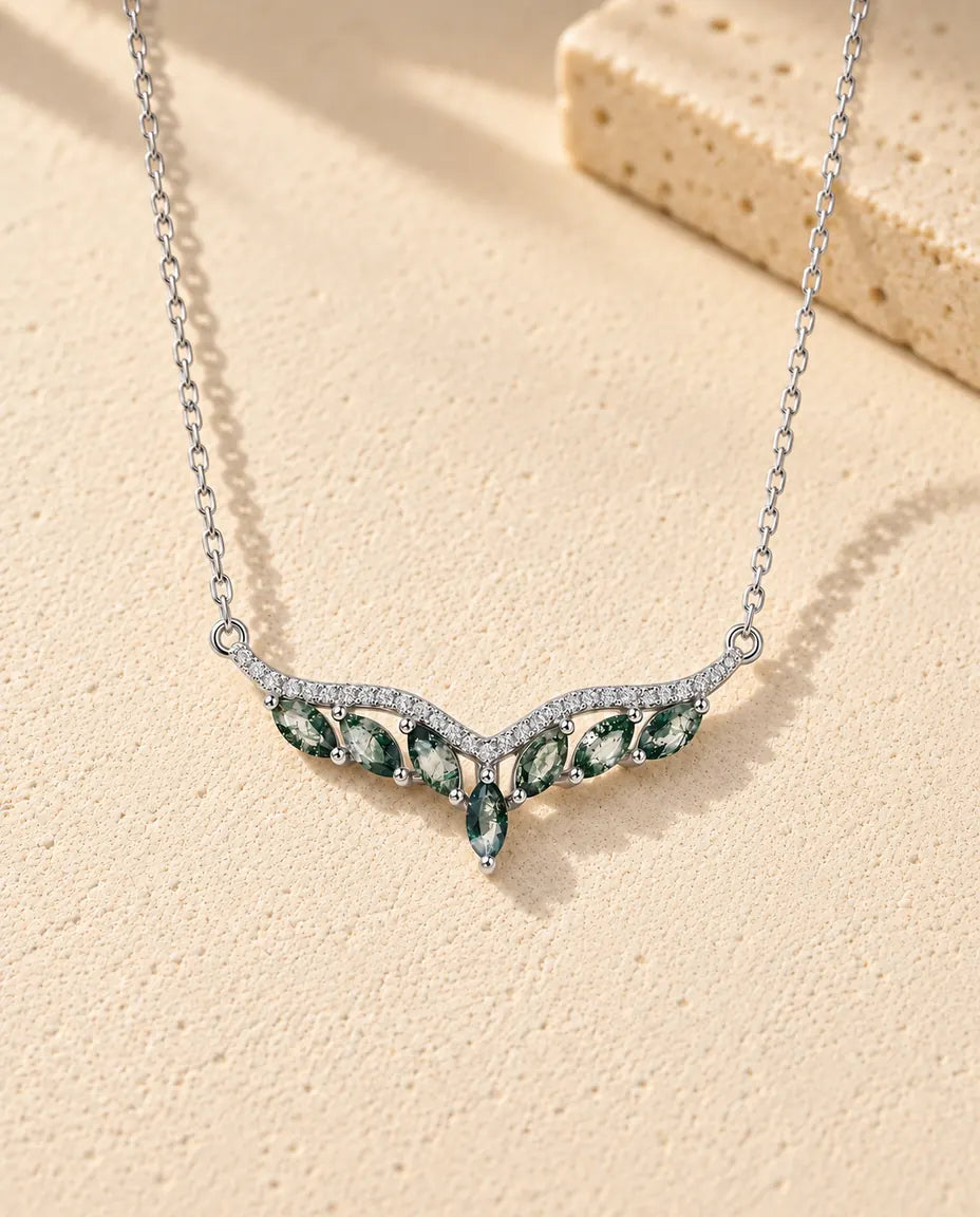 Collar de Ágata Musgosa en Plata 925 - sobre una superficie clara con textura junto a un bloque de travertino