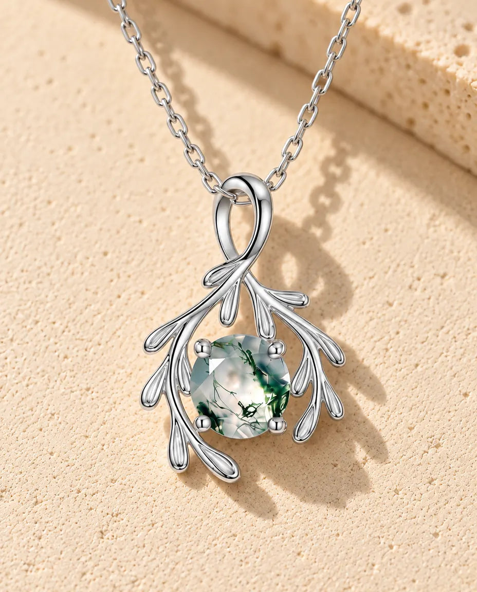 Collar de Ágata Musgosa Rama en Plata 925 - sobre una superficie clara con textura junto a un bloque de travertino