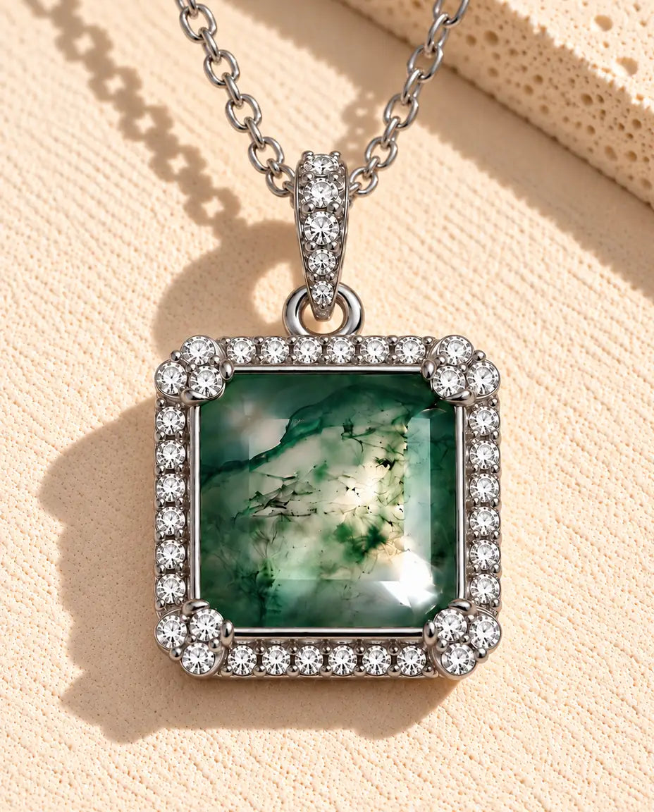 Collar de Ágata Musgosa Cuadrada en Plata 925 - sobre una superficie clara con textura junto a un bloque de travertino