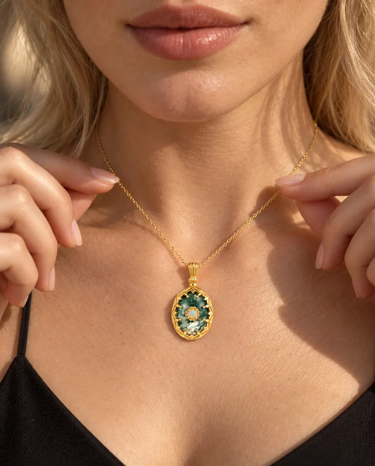 Collar de Ágata Musgosa Ovalada en Plata 925 Chapada en Oro - llevado por una modelo que sujeta la cadena con la punta de los dedos