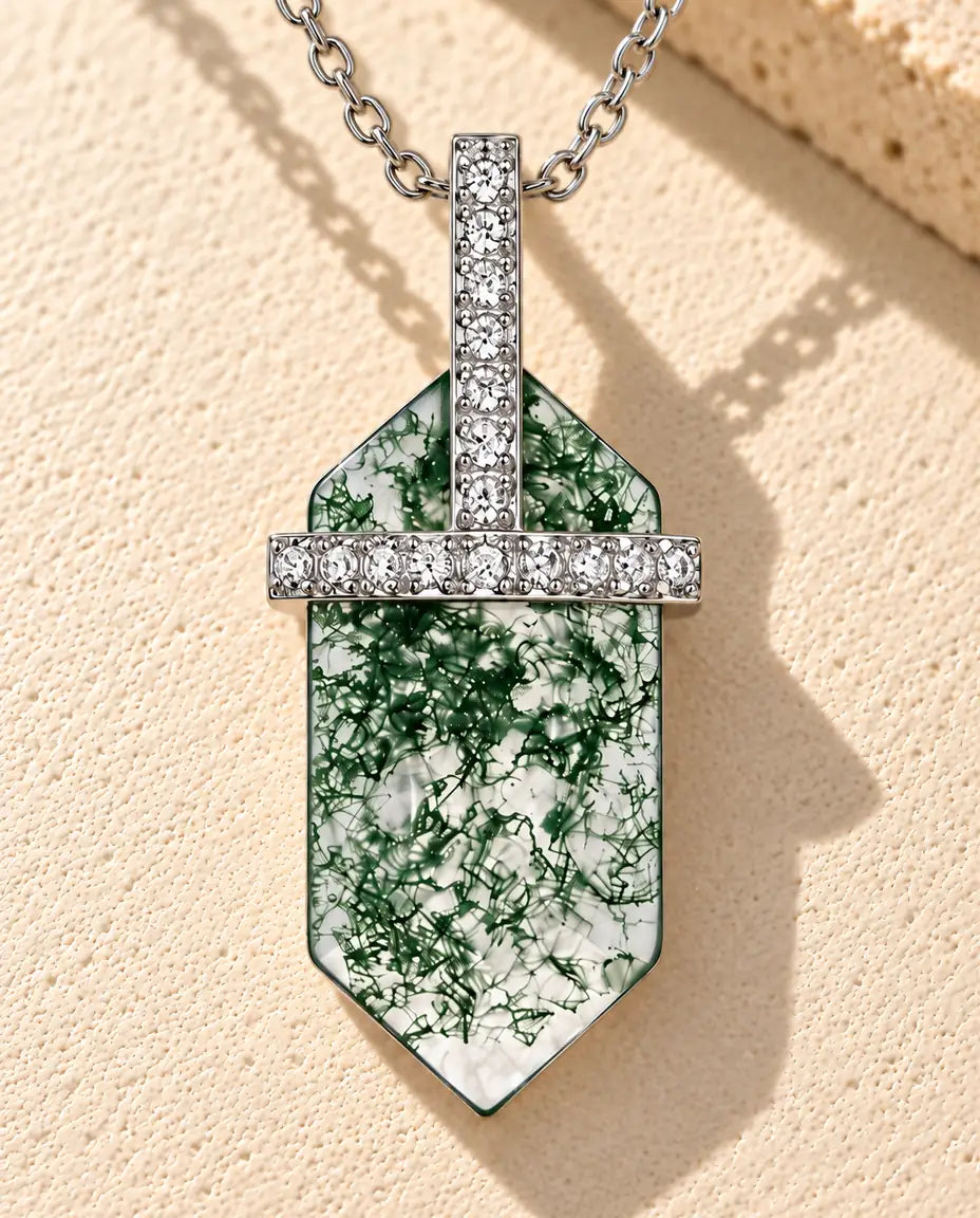 Collar de Ágata Musgosa Hexagonal en Plata 925 - sobre una superficie clara con textura junto a un bloque de travertino