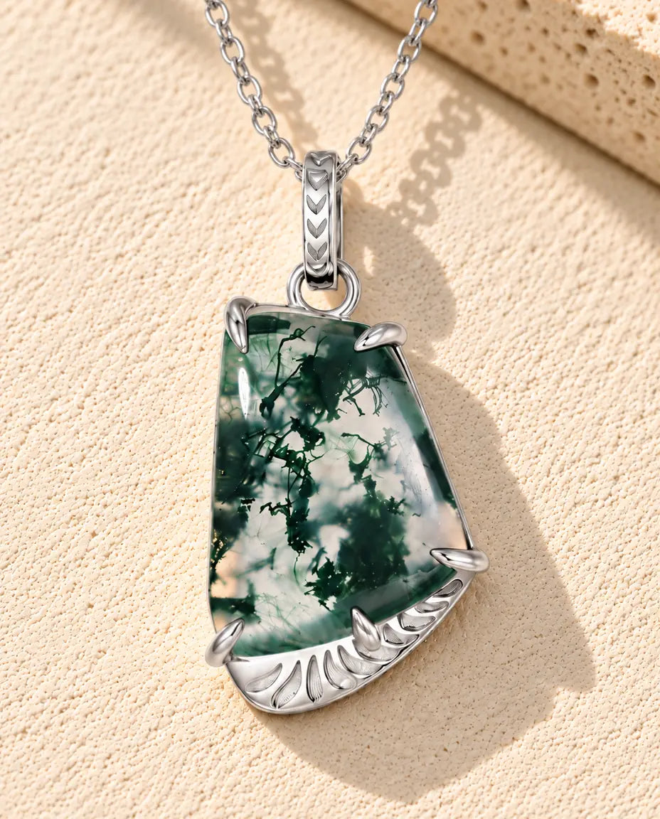 Collar de Ágata Musgosa Forma Libre en Plata 925 - sobre una superficie clara con textura junto a un bloque de travertino
