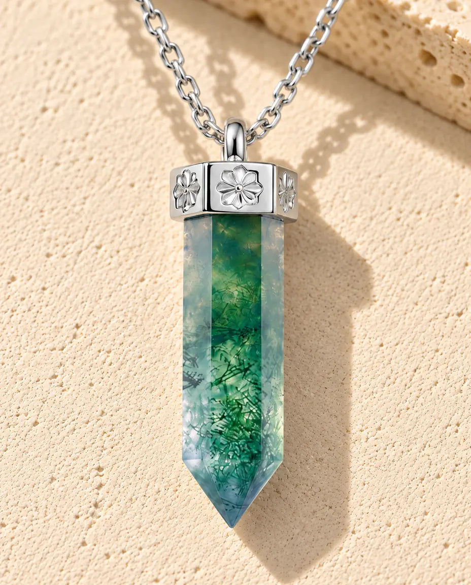 Collar de Ágata Musgosa Punta en Plata 925 - sobre una superficie clara con textura junto a un bloque de travertino