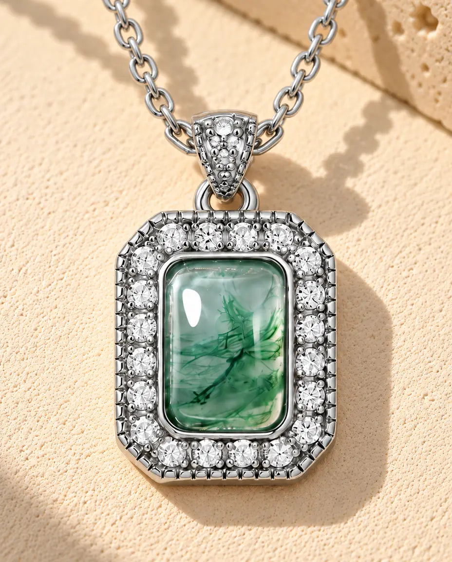 Collar de Ágata Musgosa Halo en Plata 925 - sobre una superficie clara con textura junto a un bloque de travertino