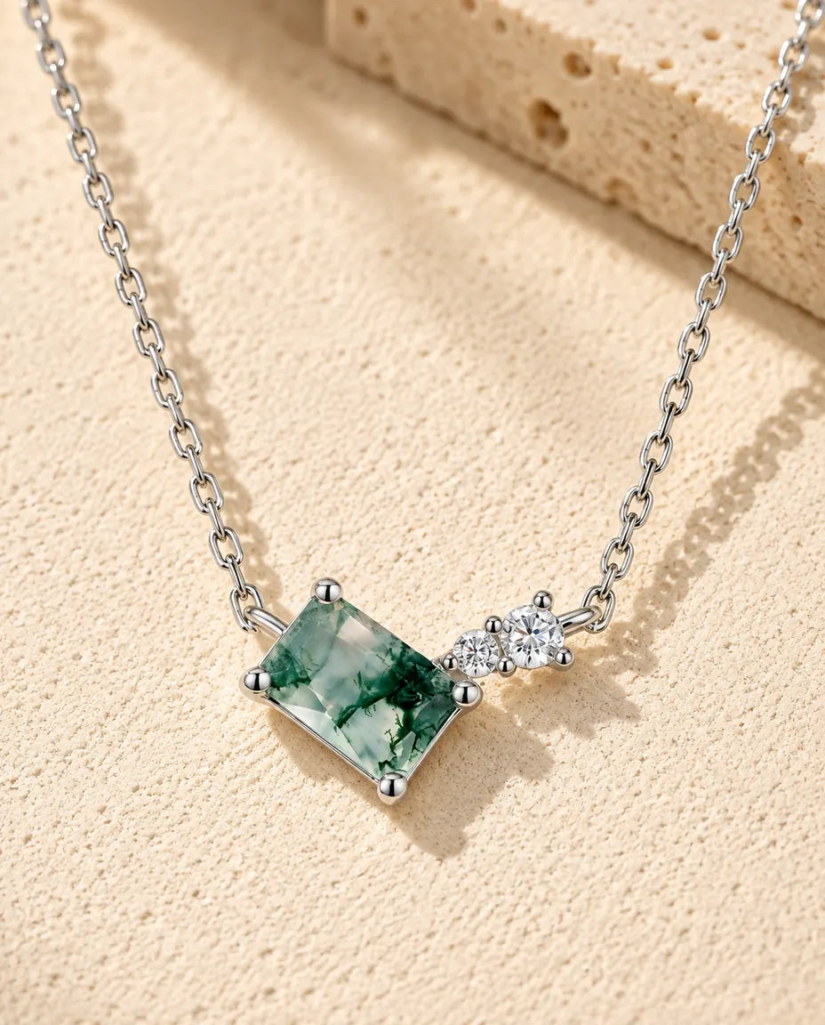 Collar de Ágata Musgosa en Plata 925 - sobre una superficie clara con textura junto a un bloque de travertino