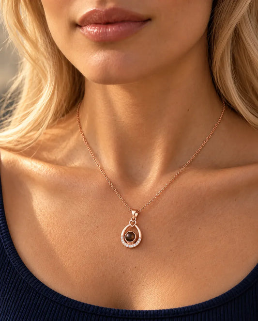 Mujer con un top azul marino que lleva el collar de gota en color oro rosa
