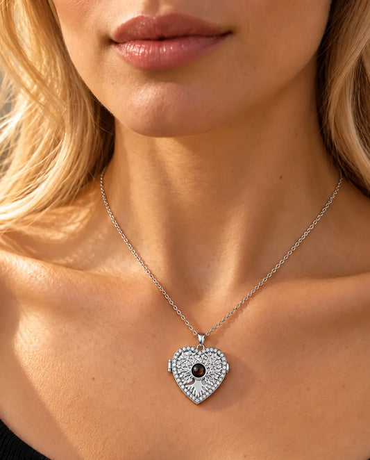 Mujer con un top negro de punto luciendo el collar relicario plateado de corazón con árbol de la vida