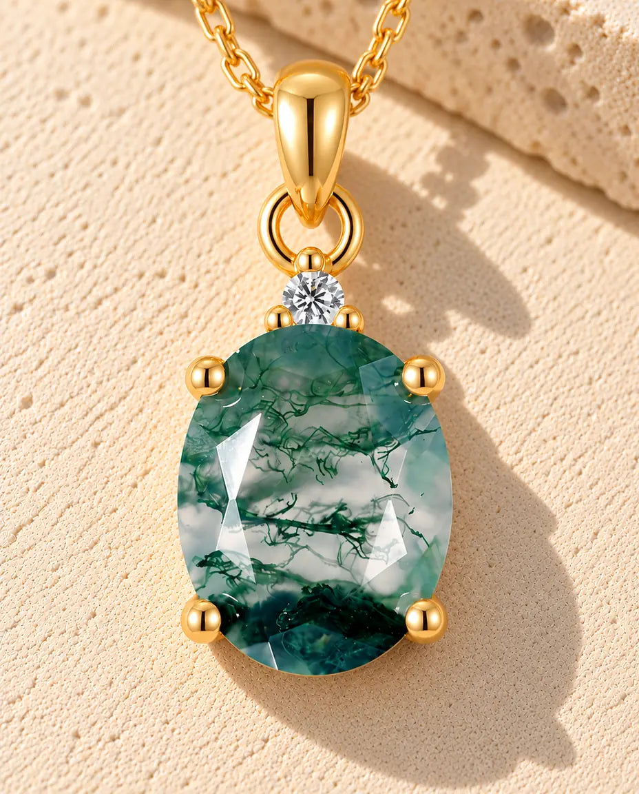 Collar Solitario de Ágata Musgosa Ovalada en Plata 925 Chapada en Oro - sobre una superficie clara con textura junto a un bloque de travertino