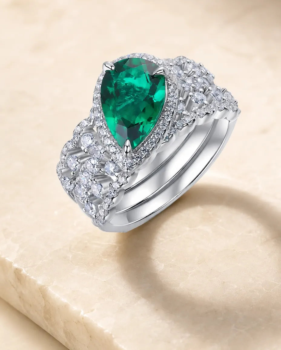 Conjunto de dos anillos de esmeralda creada en laboratorio – talla pera con halo y alianza curva, plata de ley 925