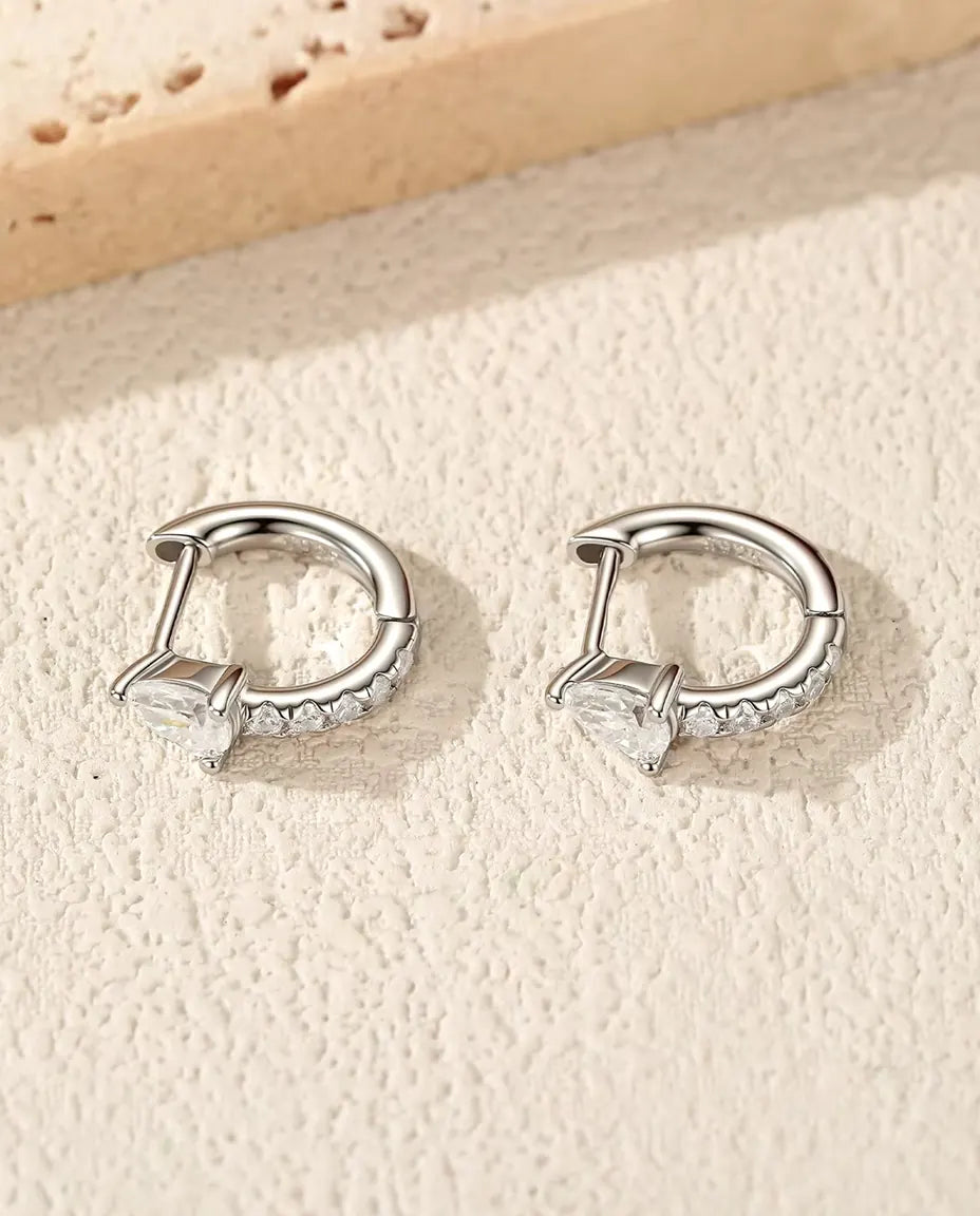 Mini Aros de Moissanita Talla Pera en Plata 925 - el par sobre una superficie clara con textura
