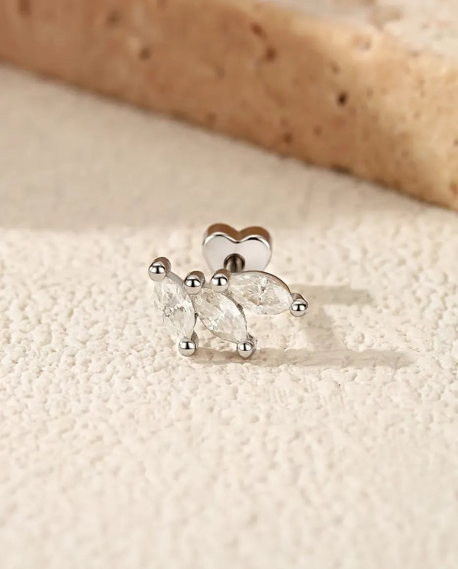 Pendientes Hoja de Moissanita Marquesa en Plata 925 - sobre una superficie clara con textura junto a una losa de travertino