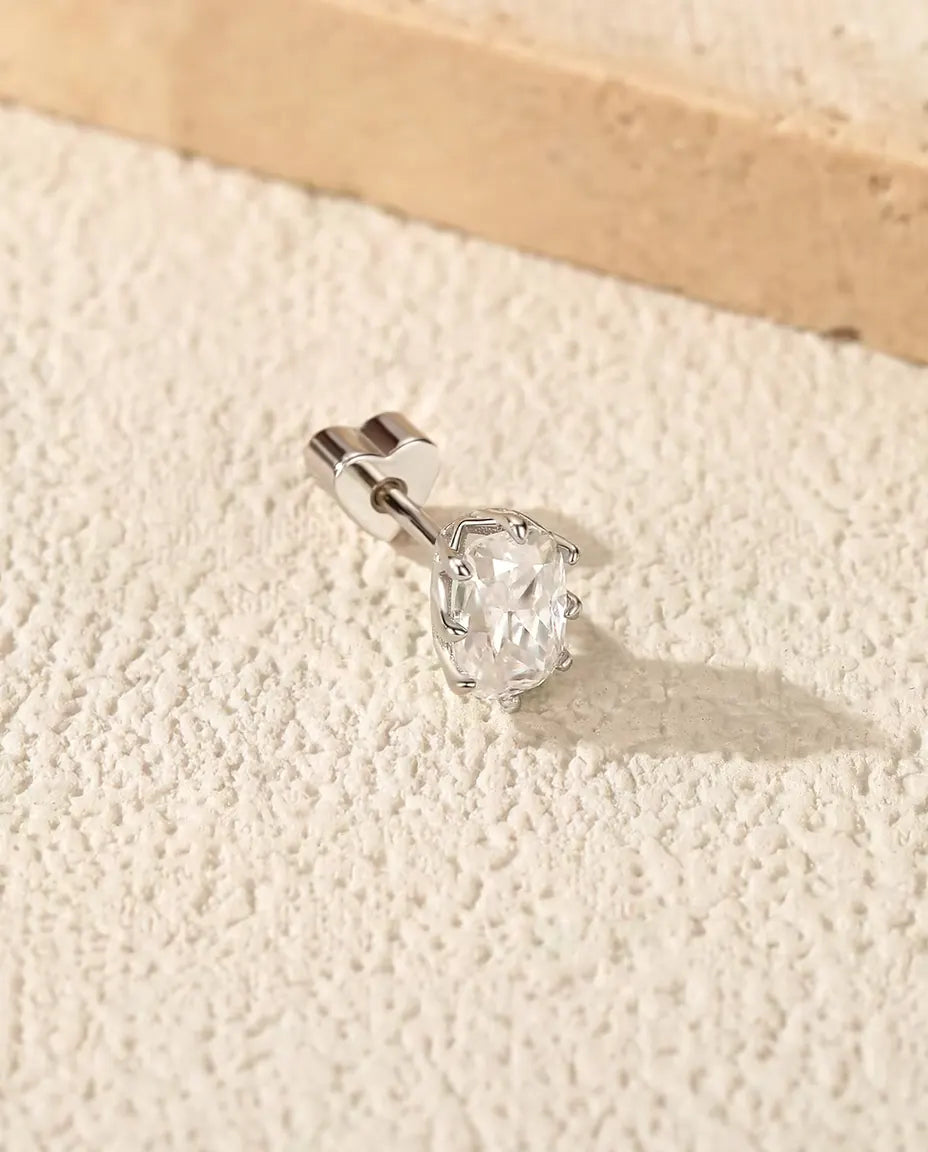 Pendientes de Moissanita Radiant en Plata 925 - sobre una superficie clara con textura junto a una losa de travertino