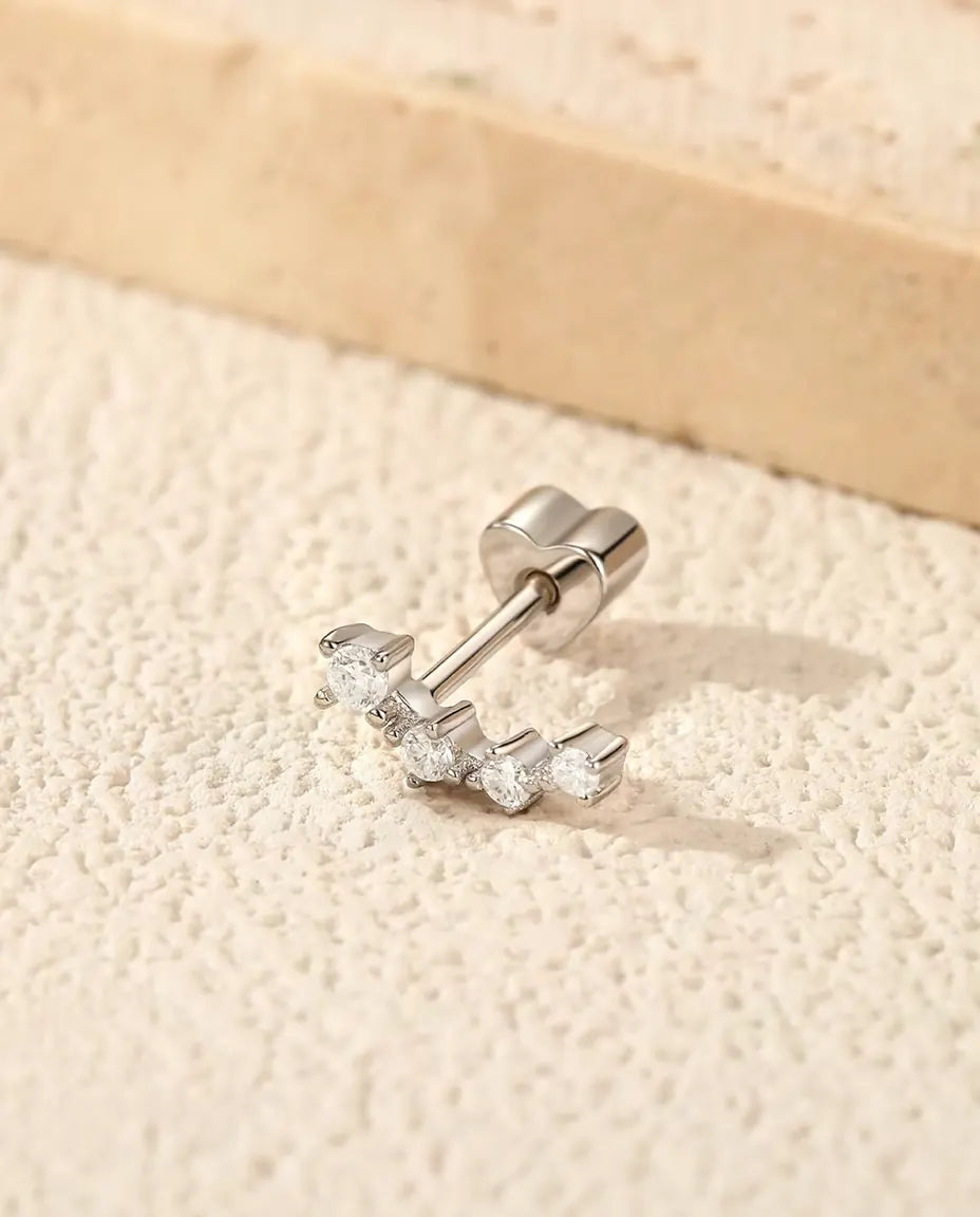 Pendientes Trepadores de Moissanita en Plata 925 - sobre una superficie clara con textura junto a una losa de travertino