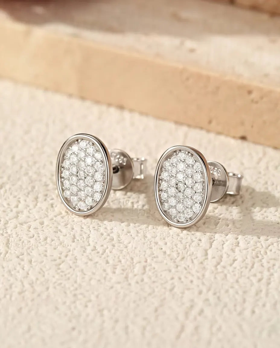Pendientes Ovalados Pavé de Moissanita en Plata 925 - el par sobre una superficie clara con textura