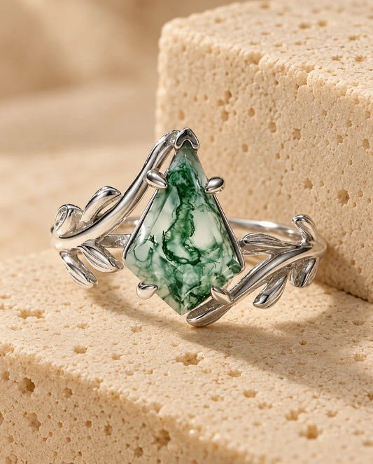 Anillo de ágata musgosa en talla cometa - expuesto sobre un bloque de travertino