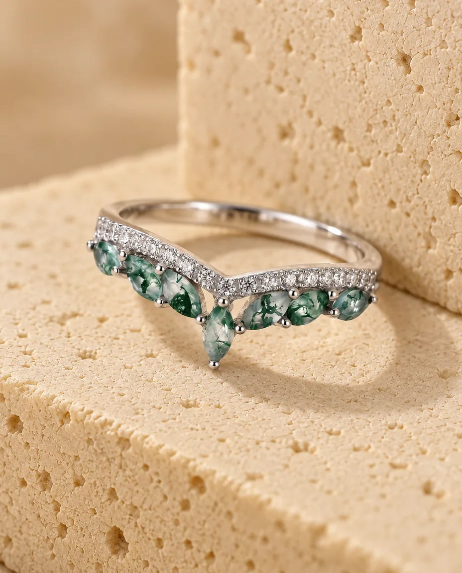 Anillo de ágata musgosa talla marquesa - expuesto sobre un bloque de travertino