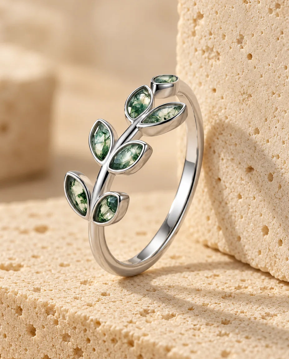 Anillo de ágata musgosa rama de olivo - expuesto sobre un bloque de travertino