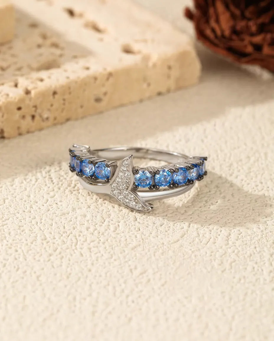 Anillo Cola de Ballena - circonitas azules y blancas sobre banda cruzada, tallas 5 a 9, plata de ley 925