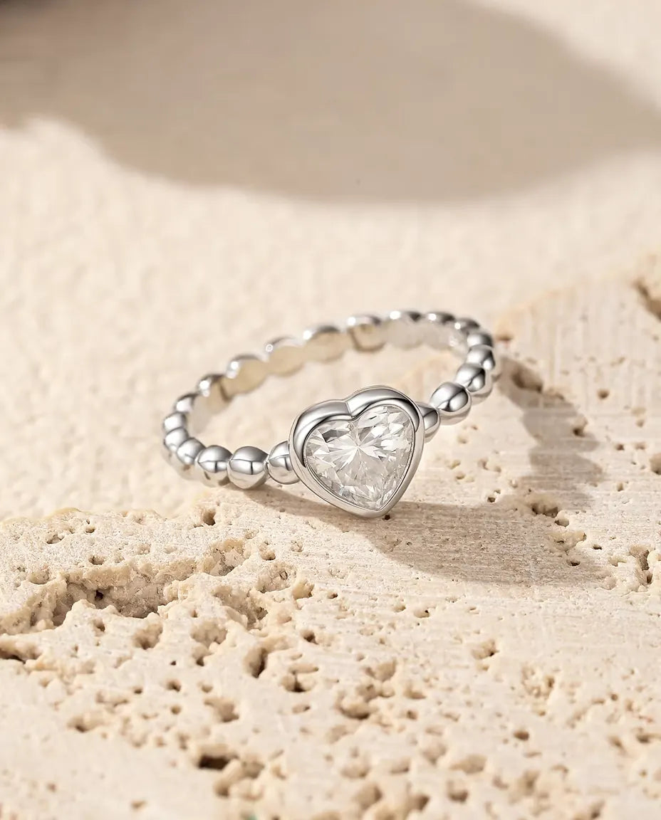 Anillo de Corazón con Moissanita en Plata 925 - sobre una superficie de travertino poroso