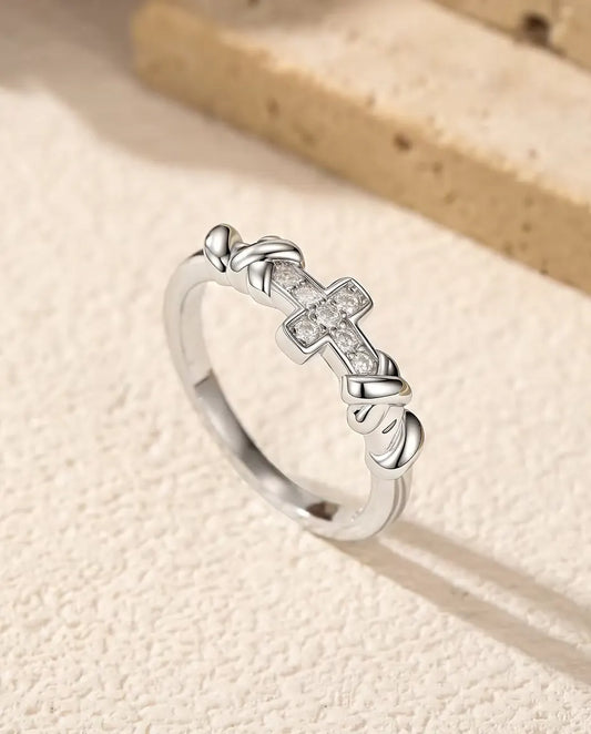 Anillo de Cruz con Moissanita en Plata 925 - de pie sobre una superficie clara con textura