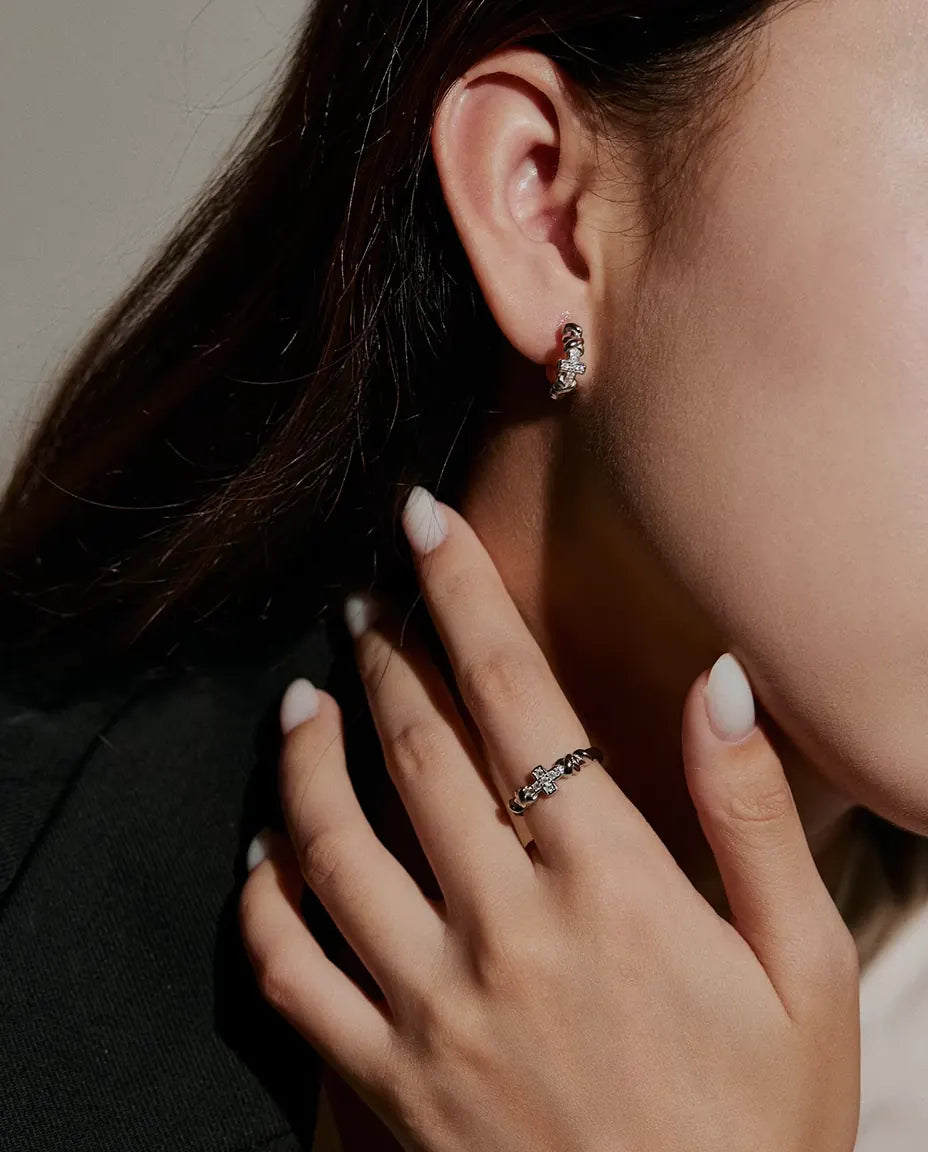 Anillo de Cruz con Moissanita en Plata 925 - llevado por una modelo con las manos cerca de la cara