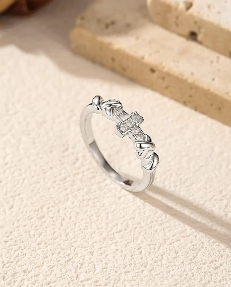 Anillo de Cruz con Moissanita en Plata 925 - de pie junto a bloques de travertino, plano más amplio