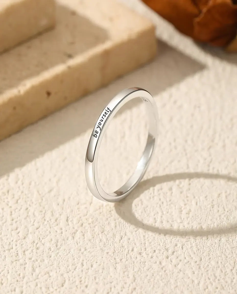 Anillo Grabado «be yourself» en Plata 925 - de pie sobre una superficie clara con textura