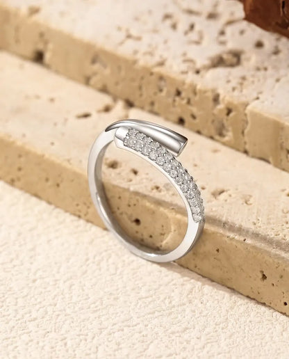 Anillo de Moissanita Abierto Cruzado en Plata 925 - apoyado en el borde de una losa de travertino