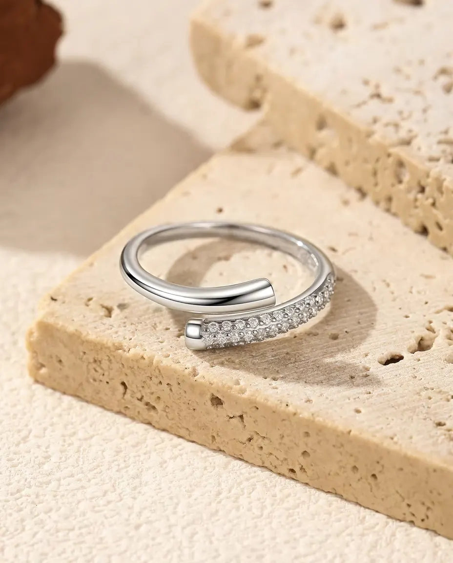 Anillo de Moissanita Abierto Cruzado en Plata 925 - tumbado sobre una losa de travertino