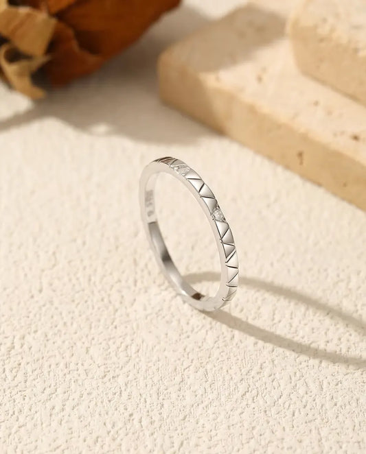 Anillo de Moissanita Apilable en Plata 925 - de pie sobre una superficie clara con textura