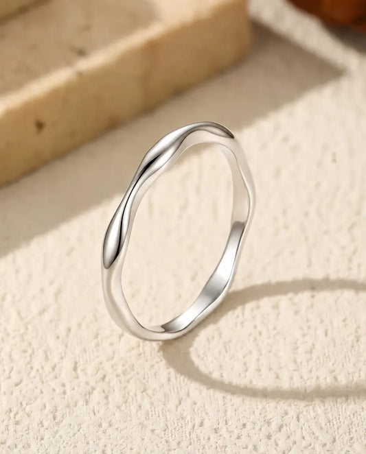 Anillo Ondulado en Plata 925 - de pie sobre una superficie clara con textura