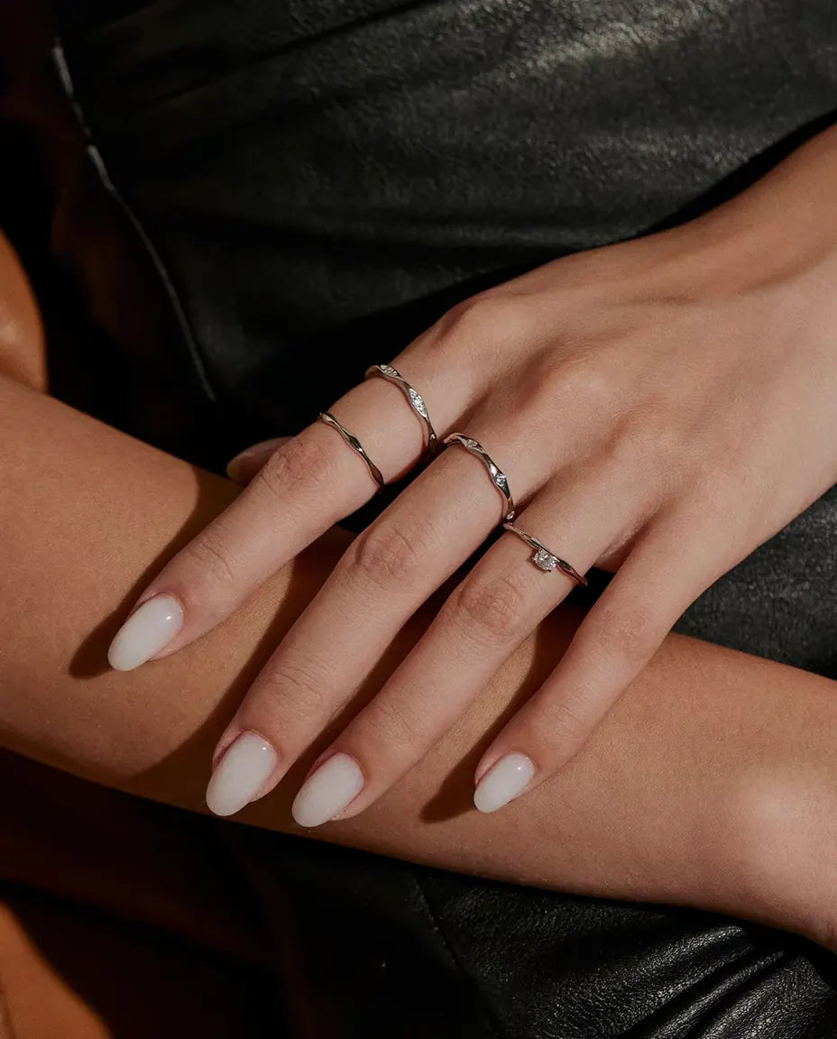 Anillo de Moissanita Ondulado en Plata 925 - llevado junto a otros anillos, con las manos una sobre otra