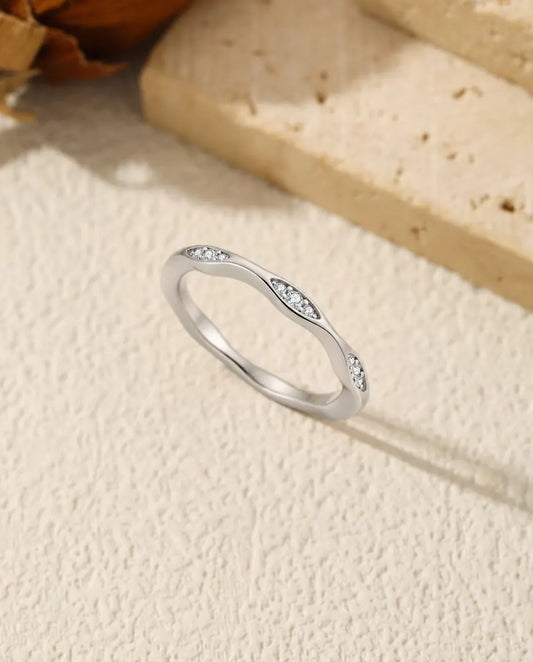 Anillo Ondulado de Moissanita en Plata 925 - de pie sobre una superficie clara con textura