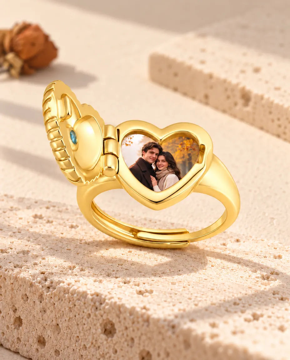 Anillo relicario de corazón abierto visto de lado, con la bisagra y la foto a la vista