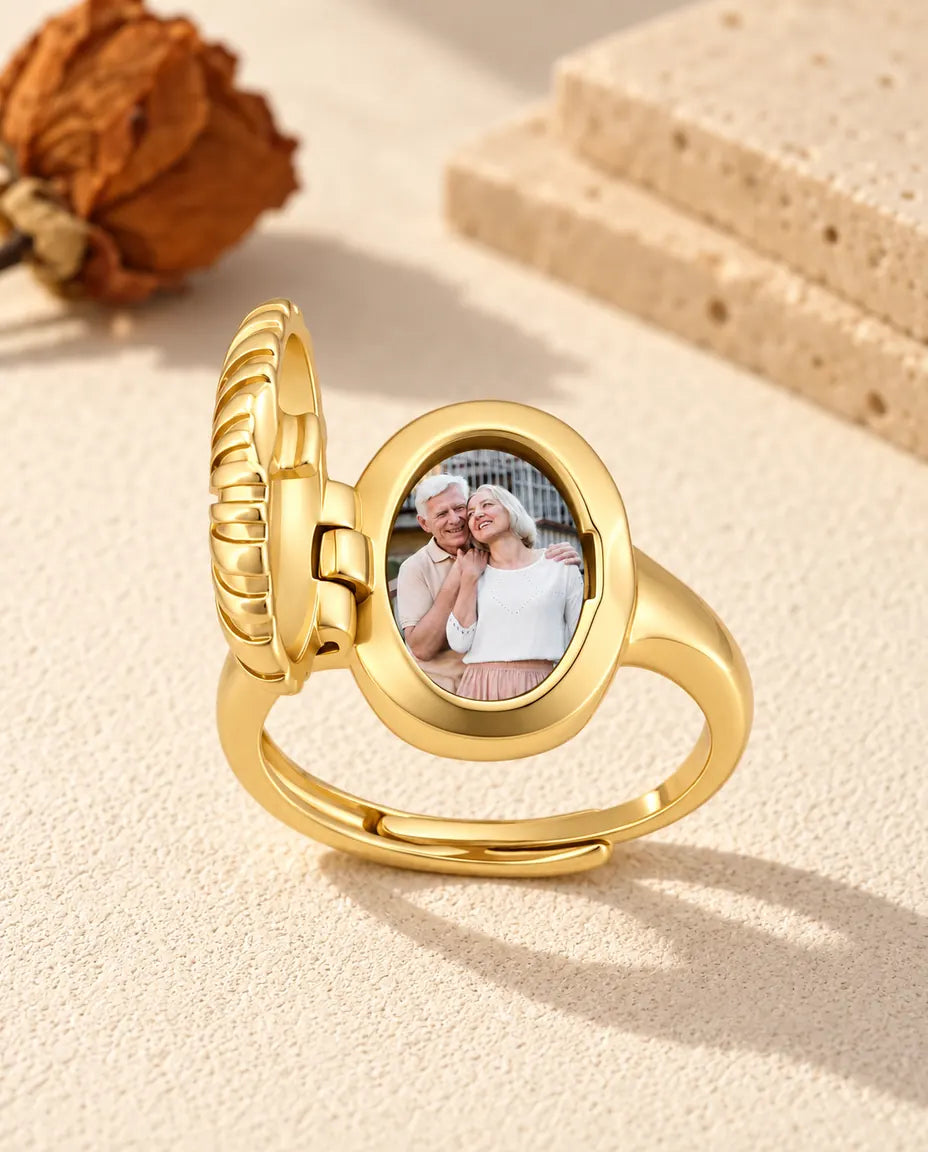 Anillo relicario ovalado abierto que muestra la foto impresa de una pareja dentro del marco