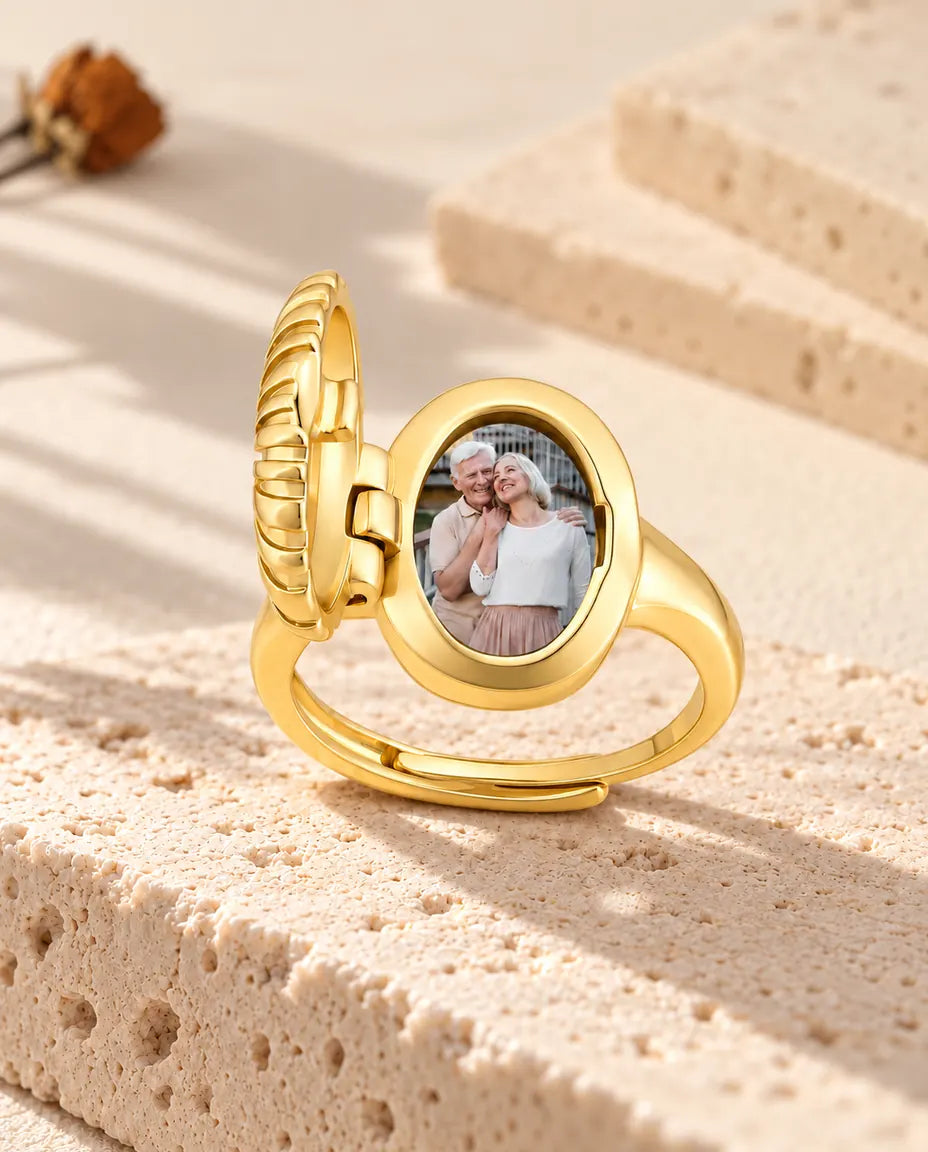 Anillo relicario ovalado abierto visto de lado, con la bisagra y la foto a la vista