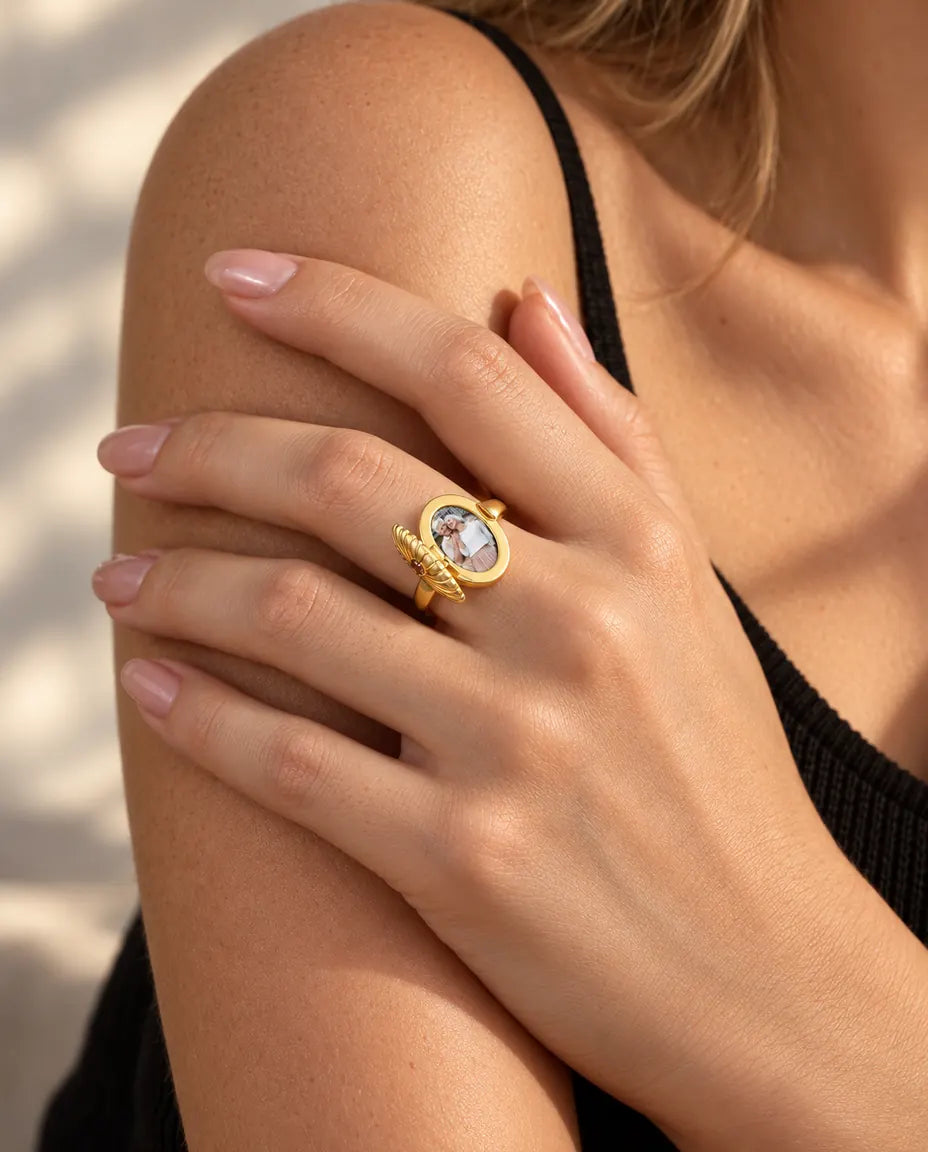 Mujer que lleva el anillo relicario ovalado abierto, con la foto visible por dentro