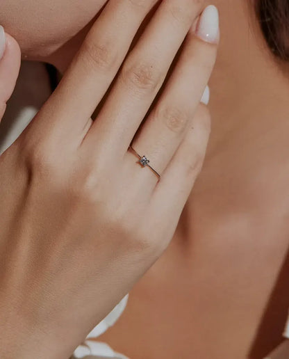 Anillo Solitario de Moissanita Fino en Plata 925 - llevado por una modelo con las manos cerca de la cara
